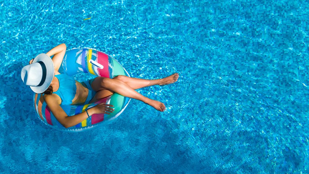 beautiful-girl-in-hat-in-swimming-pool-aerial-top-view-from-above-young-woman-relaxes-and-swims-on-inflatable-ring-donut-and-has-fun-in-water-on-family-vacation-tropical-holiday-resort (1)
