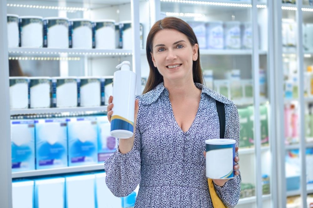 Pretty woman choosing body care products in a drugstore