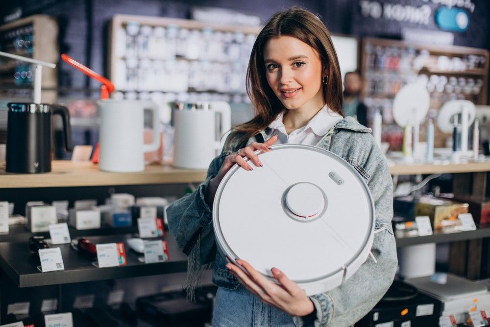 Woman buying wireless vacuum cleaner at store