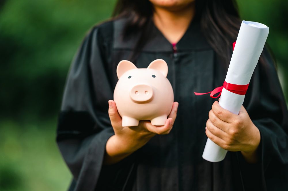 graduates-holding-piggy-banks-saving-concept